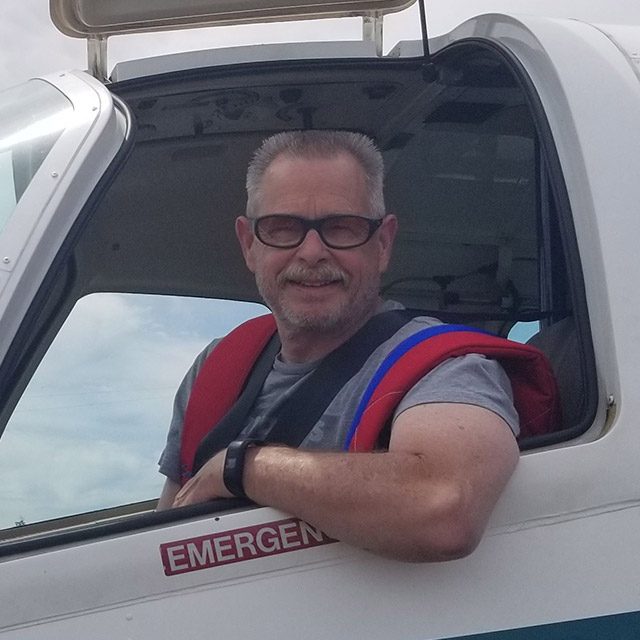 Rodney Haddon smiles out the window of the jump plane